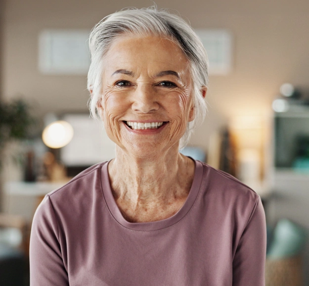 Smiling senior woman showcasing the confidence and improved quality of life that can result from full mouth reconstruction treatment