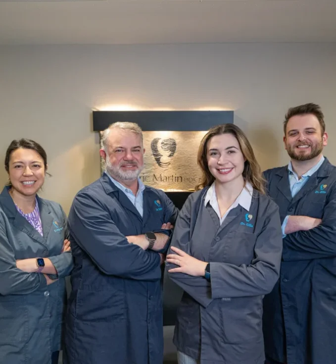The W. Eric Martin, DDS, PC dental team standing with arms crossed in the office