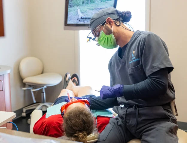 Dental hygienist performing a routine cleaning on a patient